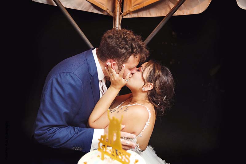 Bride and groom kiss at backyard wedding reception