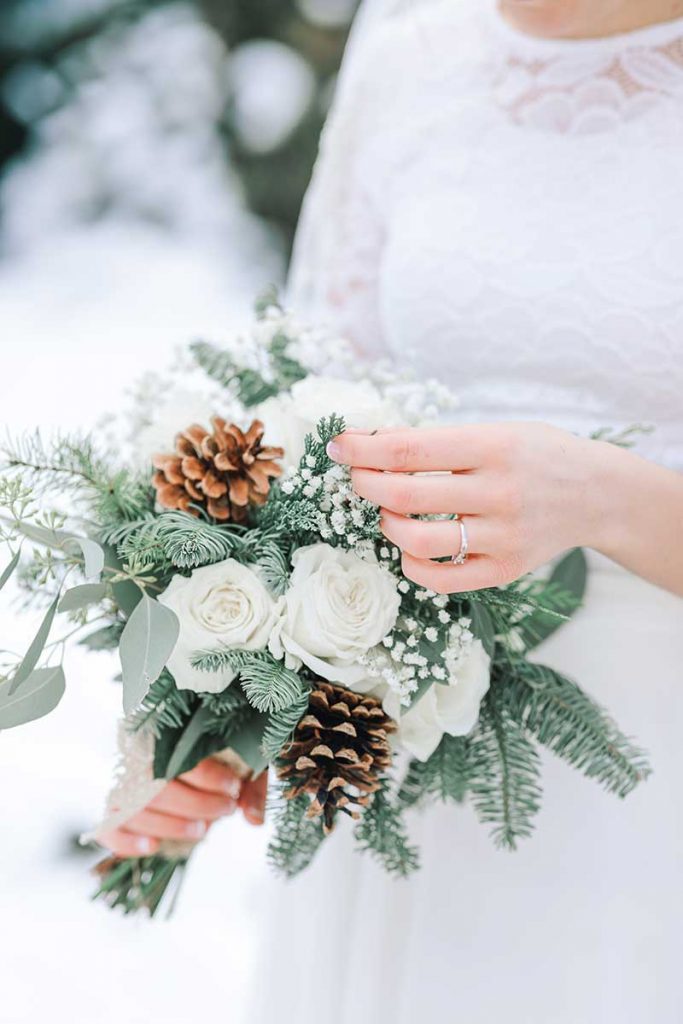 Choosing your wedding flowers for a winter wedding bouquet with pine cones and greenery