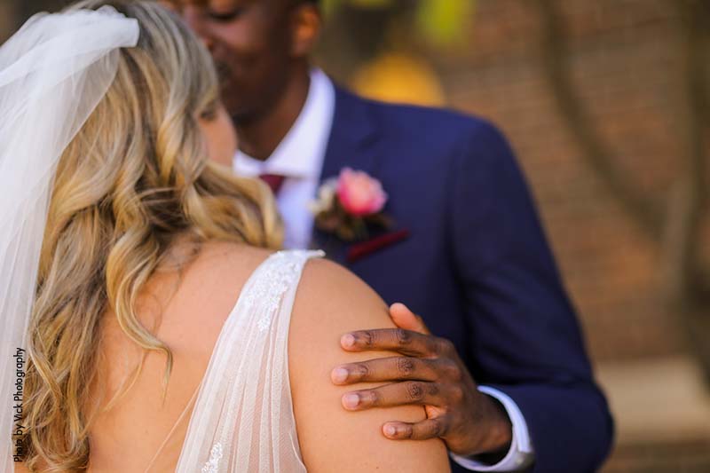 Groom puts is hand on bride's arm during first look