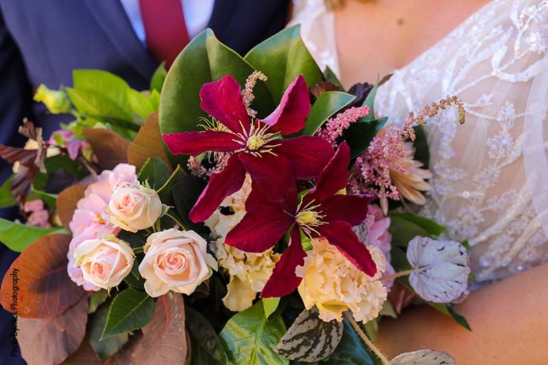 Fall bridal bouquet with maroon, pink, and white flowers and greenery