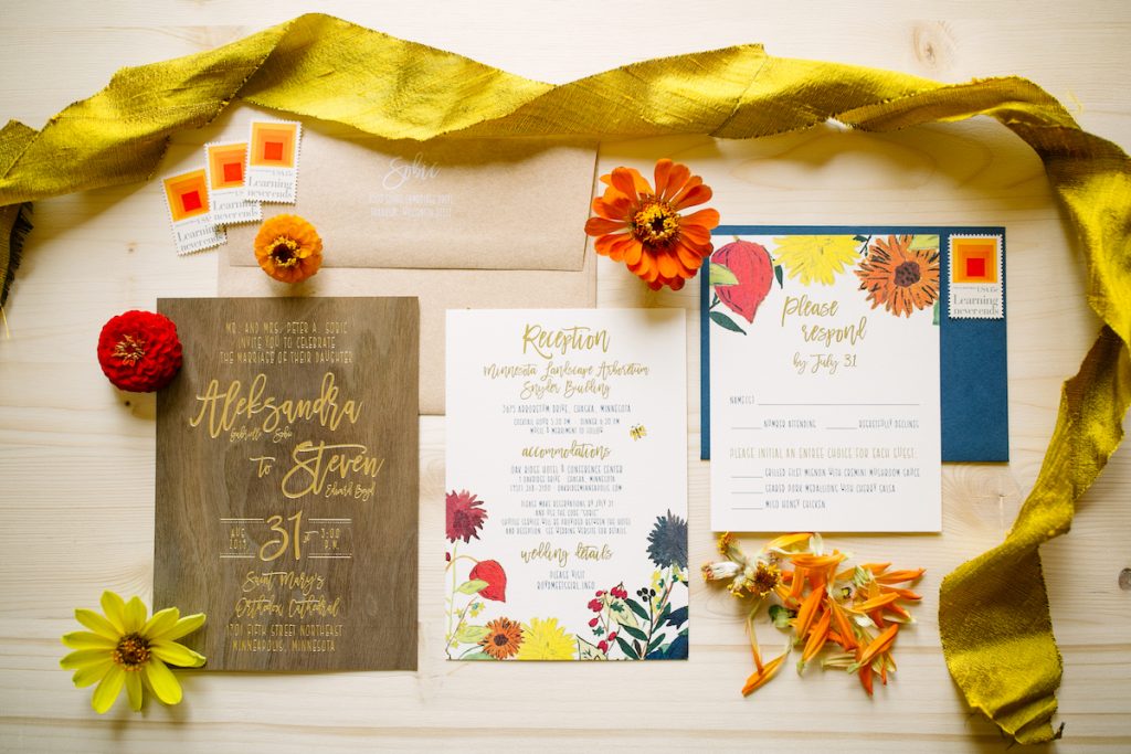 Orange and blue wedding invite on wood using wedding stationery checklist
