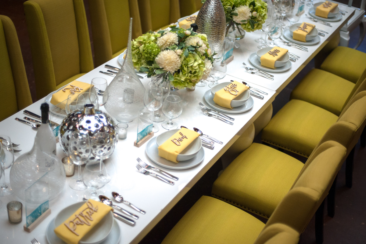 Bright wedding theme with green chairs and yelllow napkins