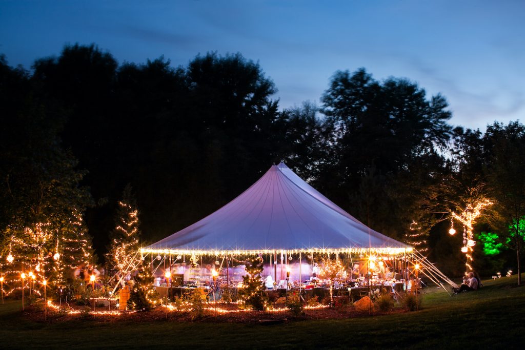 Outdoor wedding reception underneath a large tent from Ultimate Events